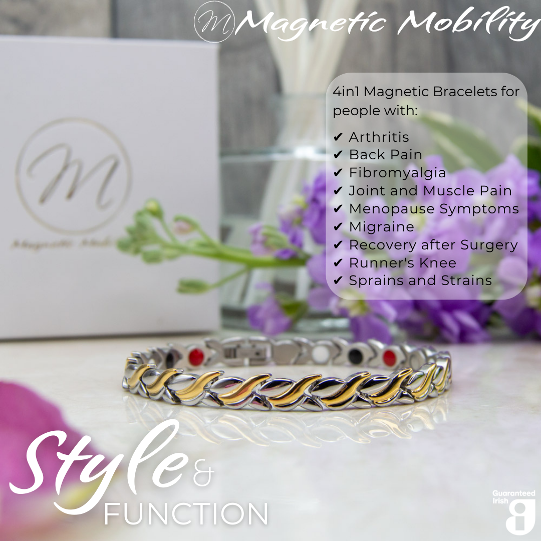 Front view of the Virginia moon 4in1 Magnetic Bracelet from Magnetic Mobility. Features and intricate Silver and Gold twist with the 4in1 elements hidden in the back. Perfect for people with arthritis, back pain, fibromyalgia, joint and muscle pain, menopause symptoms, migraine and more. The bracelet is shown on a reflective surface with purple flowers behind it and a white gift box. Features the Guaranteed Irish logo.