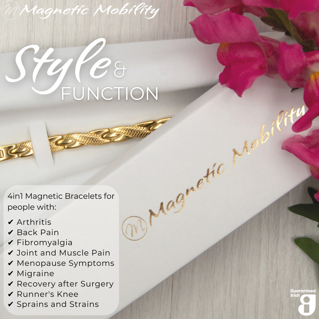 Top view of the Snapdragon Sun 4in1 Magnetic bracelet from Magnetic Mobility on a white gift box. I The bracelet is designed for people with arthritis, back pain, fibromyalgia, joint and muscle pain, menopause symptoms, migraine and more. Pink flowers are shown beside the gift box.