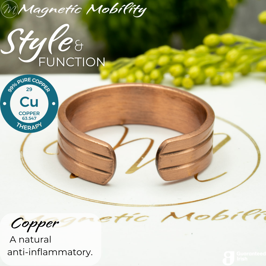 Back view of the Heath copper ring from Magnetic Mobility. Shown on a white gift box with green plants in the background. The writing says "Style and Function" and shows a Guaranteed irish logo. The back is open to allow for swelling of arthritic fingers.