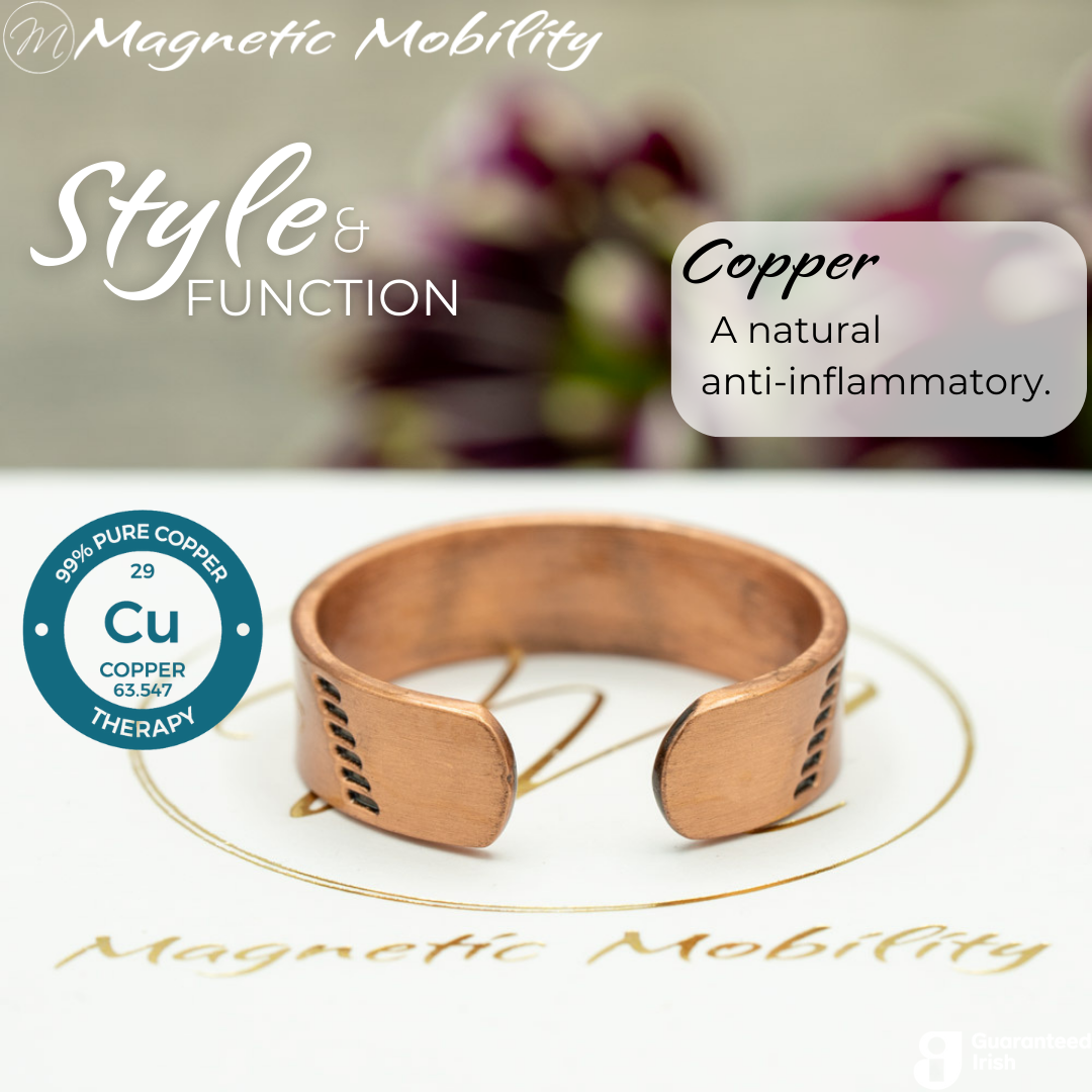 Back view of the Soloman copper ring from Magnetic Mobility. Shown on a white gift box with purple plants in the background. The writing says "Style and Function". The back is open to allow for swelling of arthritic fingers.