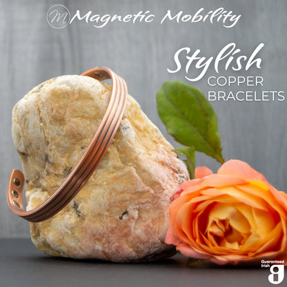 Front view of the Heath Copper bracelet from Magnetic Mobility. The bracelet features a simple design. Featured on a rock with a rose in the foreground signifying its popularity among gardeners for helping with aches and pains. Text states "Stylish Copper Bracelets" and the image features the Guaranteed Irish logo. 