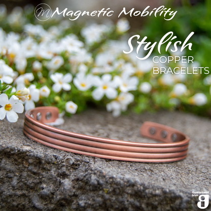 Close up view of the 3 neodymium magnets on 1 side of the heath copper bracelet from Magnetic Mobility. The copper bracelet is featured on a stone surface in a garden signifying its popularity among gardeners for helping combat aches and pains. Text states " Stylish Copper Bracelets" and the image features the Guaranteed Irish Logo. 