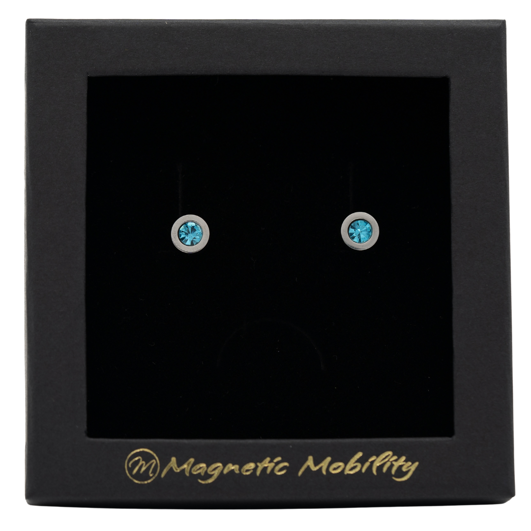 Magnetic Mobility March Birthstone Stud Earrings featuring aquamarine Swarovski crystals, elegantly presented in a black box with Magnetic Mobility branding. These magnetic back earrings offer stylish pain relief.